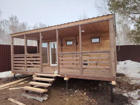 Деревянная баня с широкой террасой и ступенями
