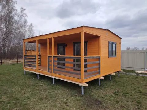 Баня с тёплым деревянным фасадом и тёмными перилами