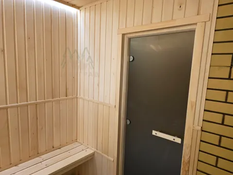 Матовая дверь и деревянная скамья в парной