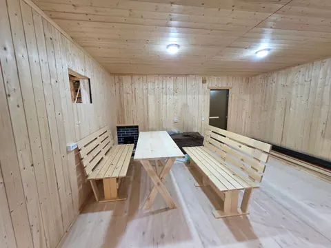 Просторная комната отдыха со столом и скамьями